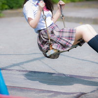 公園のブランコに座る制服姿の女子高生の写真