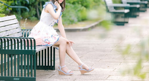 公園のベンチに座る彼女（首元を蚊に刺されてかゆい）