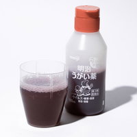 うがい薬を透明なコップにうつして希釈するの写真