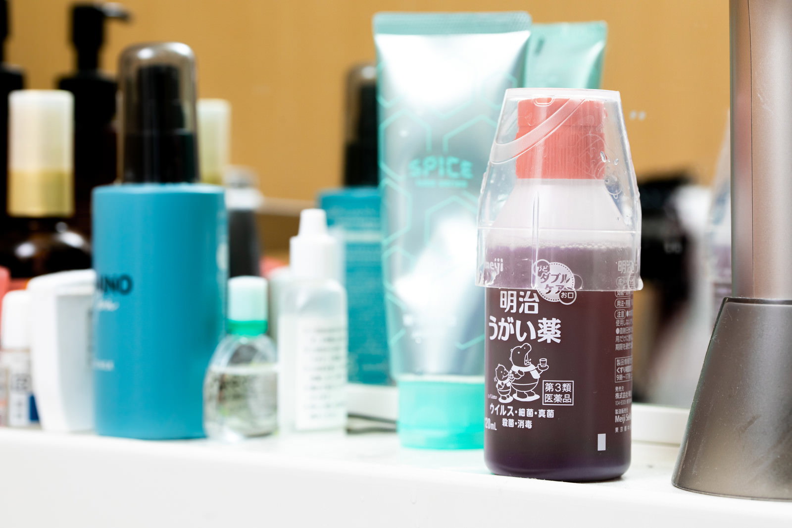 洗面台に並ぶうがい薬と青色のボトルなど洗面用品