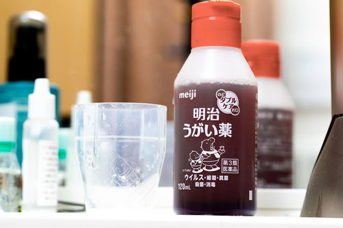 洗面所に置かれたうがい薬とコップ、毎日の感染症予防と健康管理