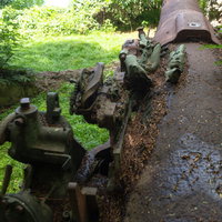 破壊された砲の上に残る潰れた薬莢の写真