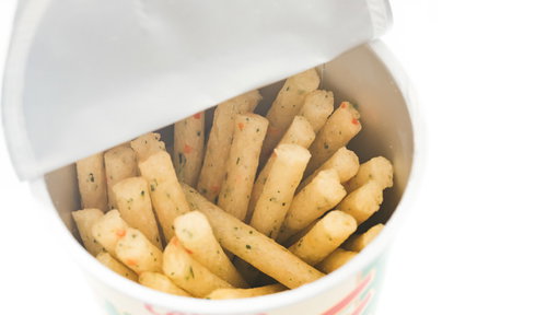 白い袋から出ている黄色い棒状のスナック菓子じゃがアリゴ