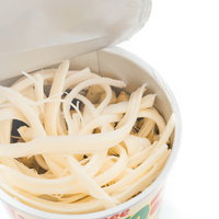駄菓子の白い容器にさけたチーズを乗せた組み合わせの写真
