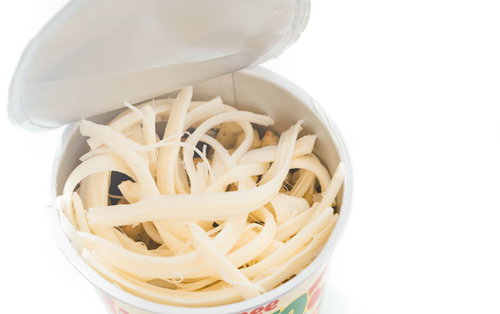 駄菓子の白い容器にさけたチーズを乗せた組み合わせ