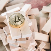 不安定な積み木の上に置かれたビットコインの写真