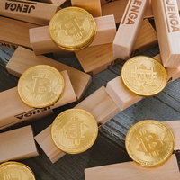 ジェンガの上に積まれた金色のビットコインの写真