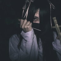 五寸釘を握る藁人形と地雷系女子の呪いの演出の写真