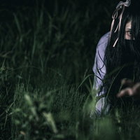 暗い草むらで四つん這いになって這う地雷女子の写真