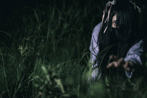暗い草むらで四つん這いになって這う地雷女子