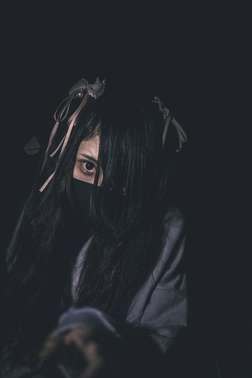 暗い背景で髪を覆う地雷系怨念女子のホラー