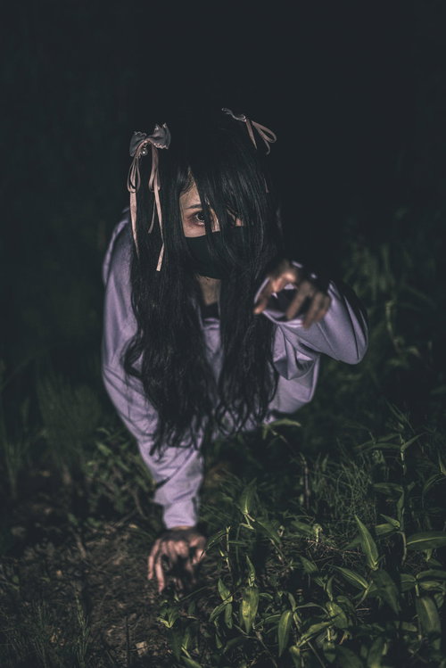紫色の衣服を纏い暗い草地で這いつくばる地雷系女子の怨霊