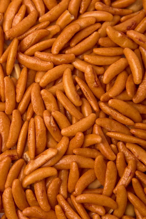 一面のあられ、オレンジ色の柿の種、三日月形の米菓