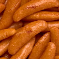 オレンジ色に焼き上げた柿の種のあられ表面の傷の写真