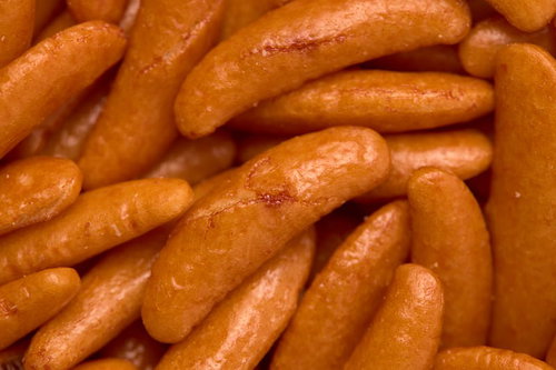 オレンジ色に焼き上げた柿の種のあられ表面の傷