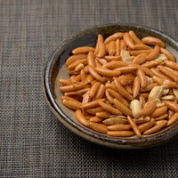 木皿に盛られたあられ菓子（柿の種）とピーナッツの写真