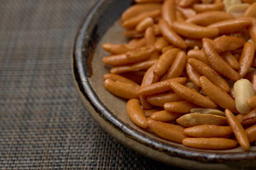 茶色い小皿に盛った柿の種とピーナッツのおつまみ