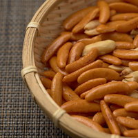 竹のザルに盛った柿の種とピーナッツのおつまみの写真