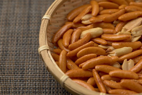 竹のザルに盛った柿の種とピーナッツのおつまみ