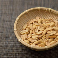 木製の笊に盛られたピーナッツと落花生の食品の写真