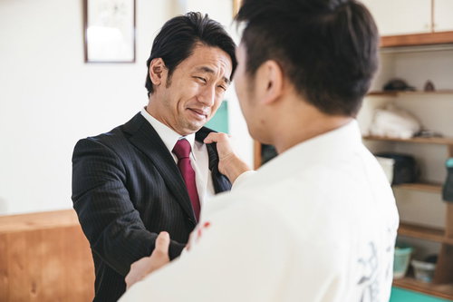 投げ技におびえるスーツ姿のサラリーマン男性