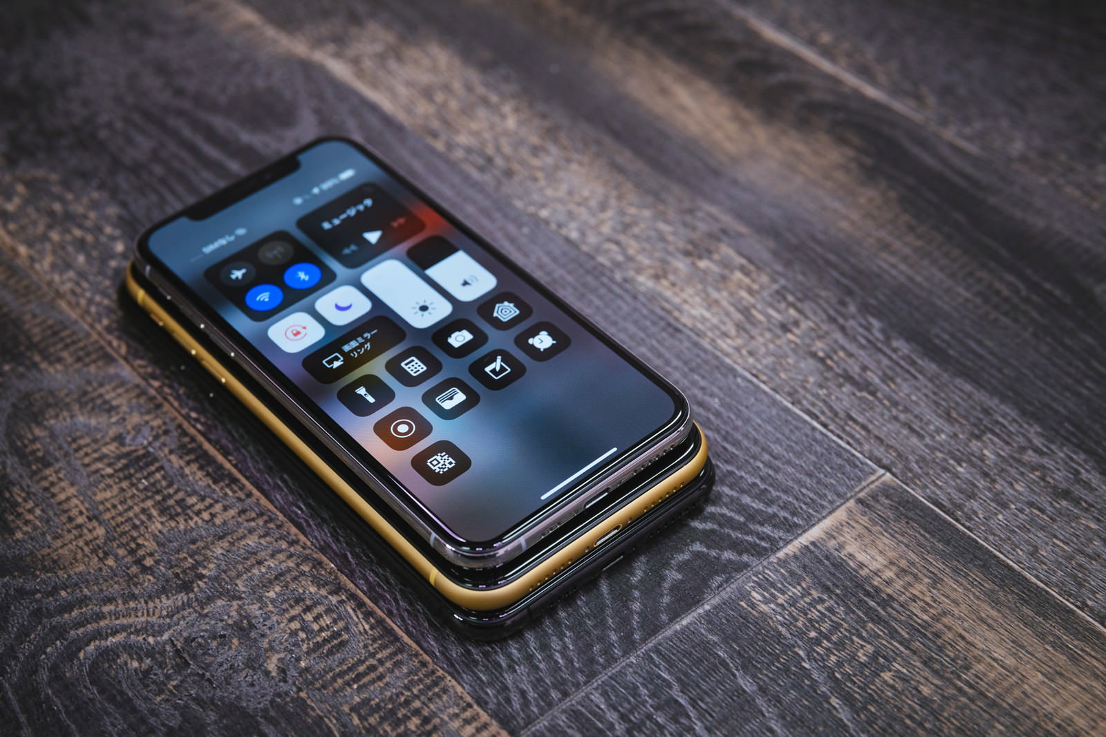 フローリングの上でコントロールセンターを表示したiPhone
