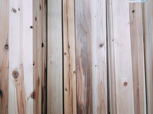立てかけられた板のテクスチャ、自然な木目と節が並ぶ木材