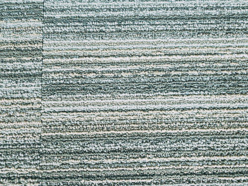 グレーのタイルカーペットの継ぎ目と規則的なテクスチャー