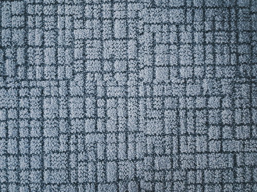 グレーの格子模様が入った擦れた絨毯のテクスチャー