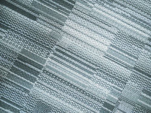 斜めから見たグレー系カーペットの織り目と繊維質感