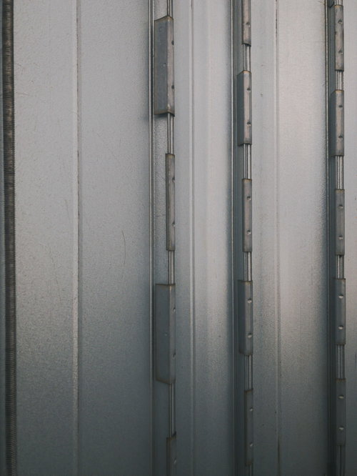 グレーの金属製室外ダクトとフランジ壁の接続部