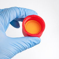 青い医療用手袋で赤いキャップの除草剤容器を持つの写真