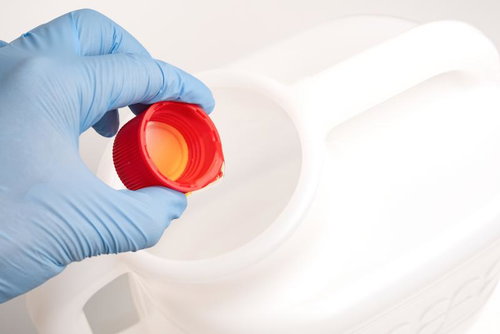 医療用検査機器の赤いキャップを青いラテックス手袋で持つ