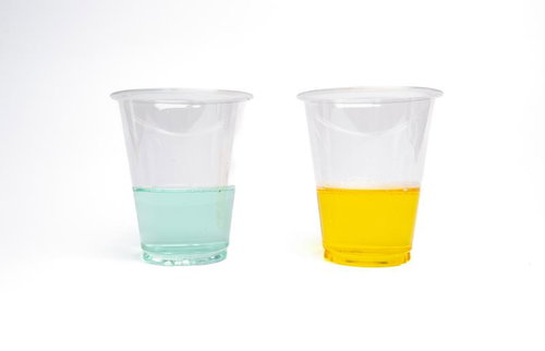 透明カップに入った緑と黄色の液体、除草剤と実験薬品