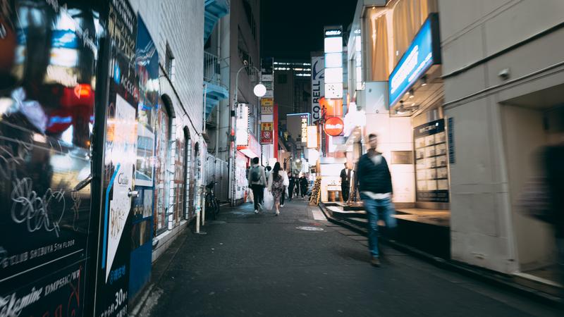 夜の道玄坂小路に並ぶ店舗と人々の風景