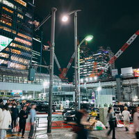 多くの人が往来する夜の宮益坂下交差点、ネオンに照らされた渋谷の繁華街の写真