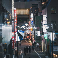 夜のセルリアンタワー通り、ネオン看板と人々が行き交う渋谷中央街の夜景の写真