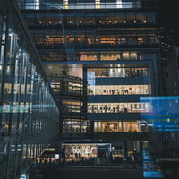 東京渋谷ヒカリエの夜景、ガラス張りの歩道橋から見下ろす店舗群の写真