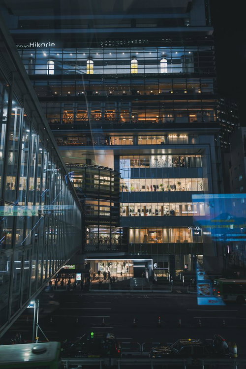 東京渋谷ヒカリエの夜景、ガラス張りの歩道橋から見下ろす店舗群