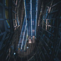 ガラス天井に映るエスカレーターの反射で生まれる幾何学模様の写真