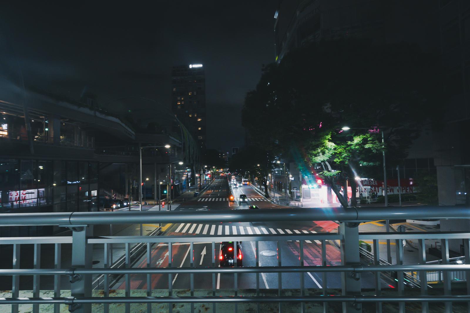 渋谷駅前の歩道橋から見下ろす夜の明治通りと高層ビル群の夜景