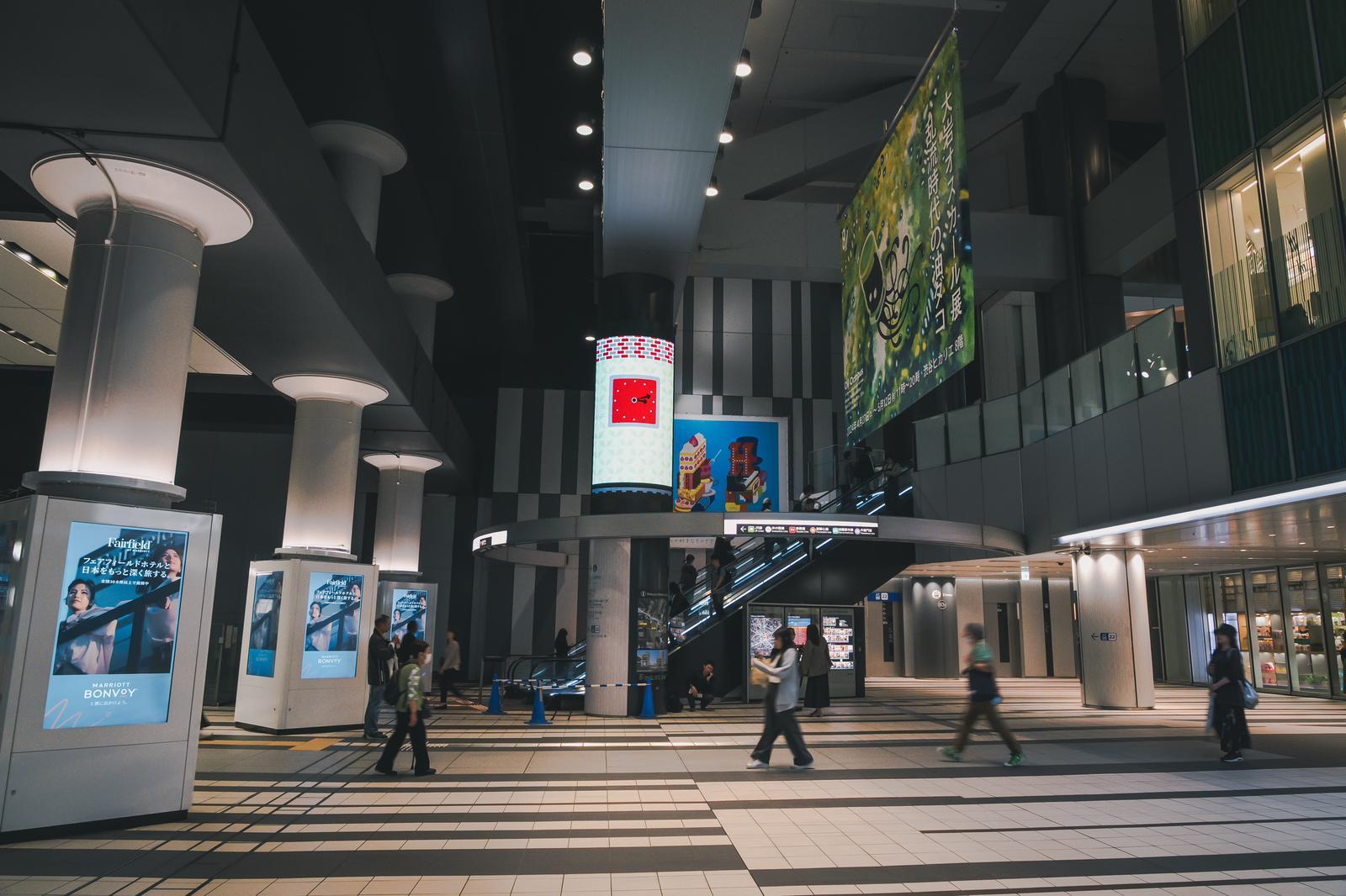 渋谷ヒカリエShinQsの地下1階、照明が灯る館内で複数の人々が歩いている