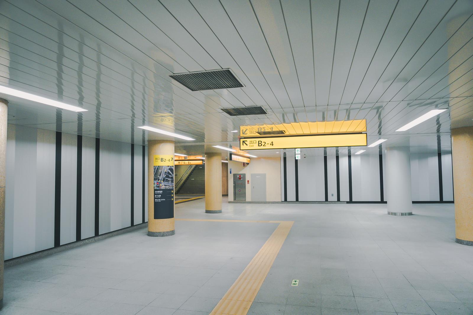 The interior of Shibuya Station on the Tokyo Metro Fukutoshin Line, with yellow signage and black-and-white wall patterns visible.