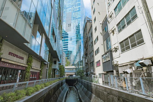 渋谷川沿いの運河と高層ビル、モダン建築と古い建物の対比