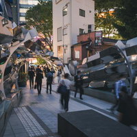 渋谷マークシティの道玄坂、夜間の現代アート展示と行き交う人々の写真