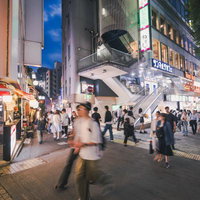 夜間の渋谷・道玄坂と小路入口の街並みの写真