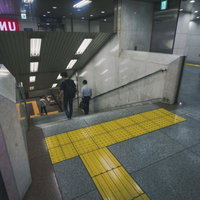 渋谷駅出口A0の階段と点字ブロック、駅構内の安全誘導施設の写真