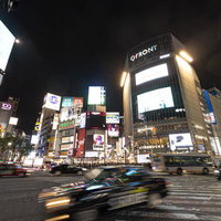 夜間の渋谷スクランブル交差点を行き交う車と人混みの写真