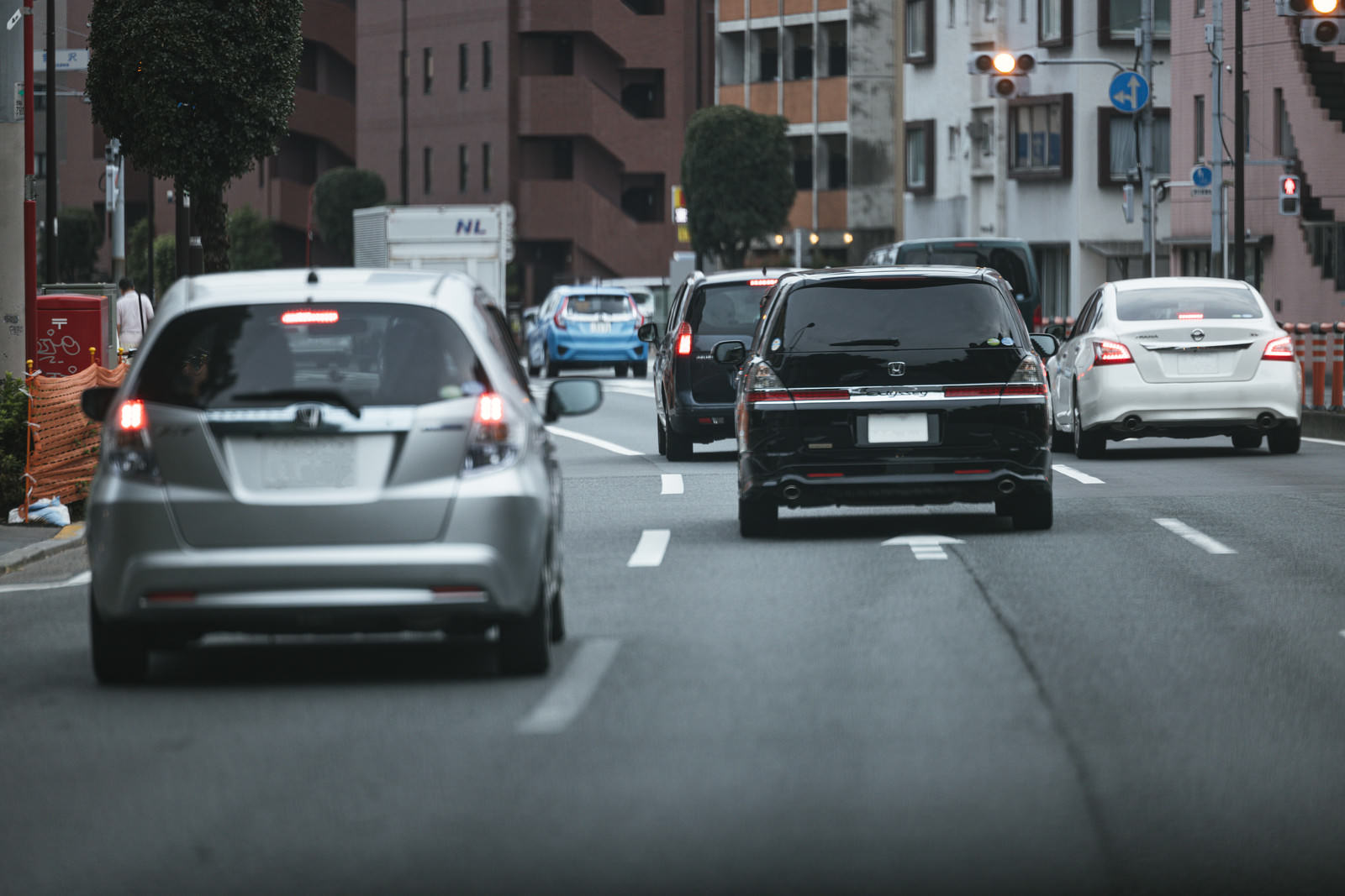車間距離を適切に取って公道を走行する複数の車両とテールランプ