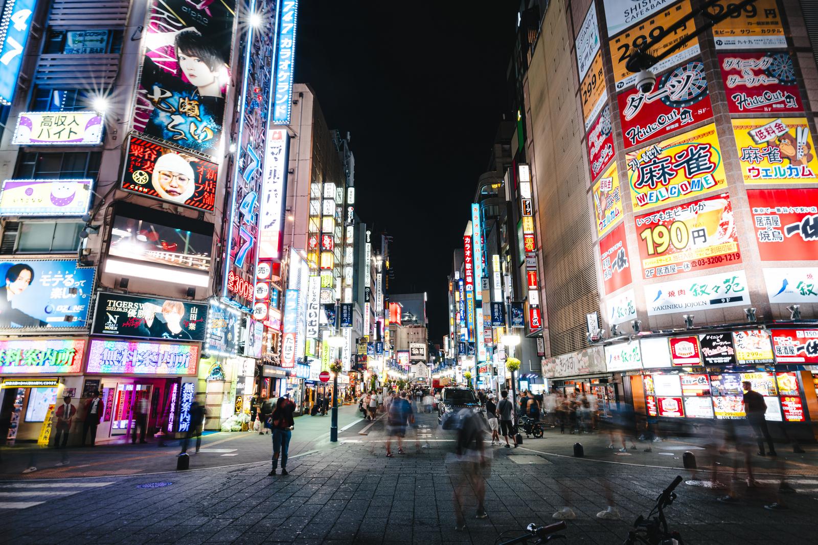 新宿歌舞伎町セントラルロードの夜間風景。多数のネオン看板に照らされた人混みの歩道